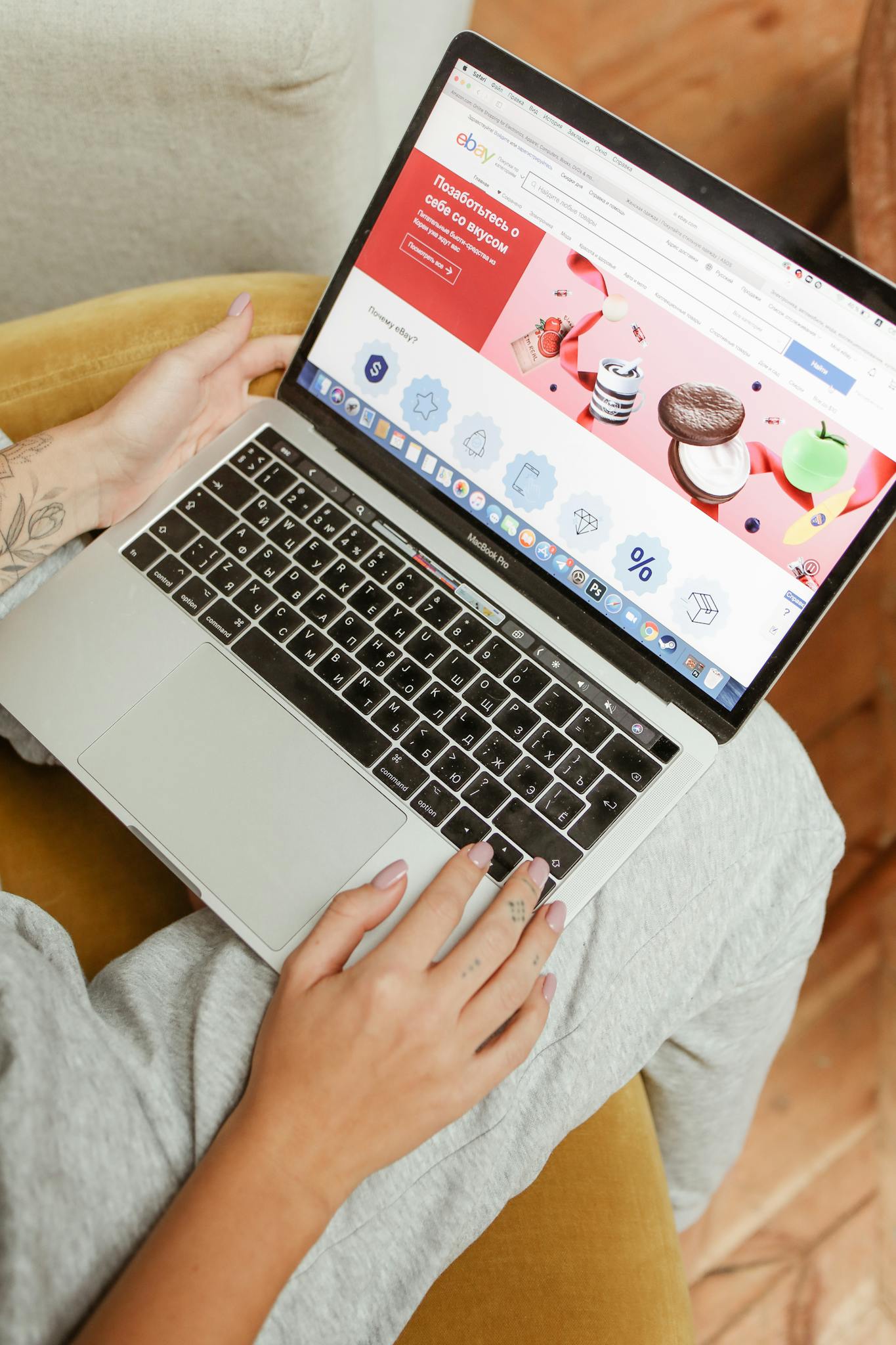 A woman sits comfortably indoors, browsing an online shopping website on her laptop.