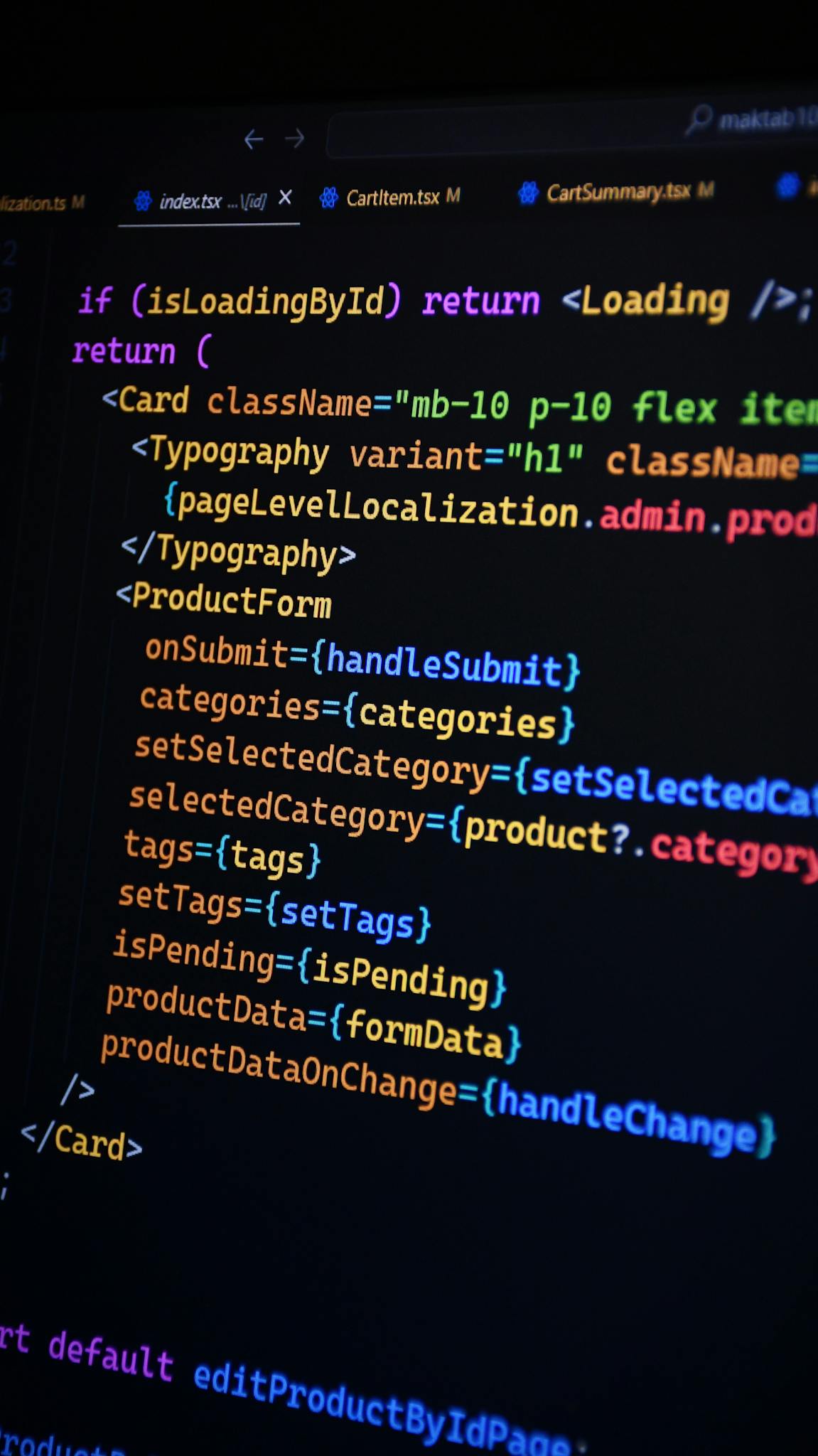 Close-up of JSX code on a monitor, showcasing colorful syntax used in ReactJS development.